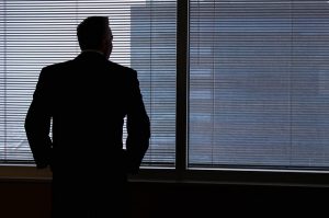 man staring out of window